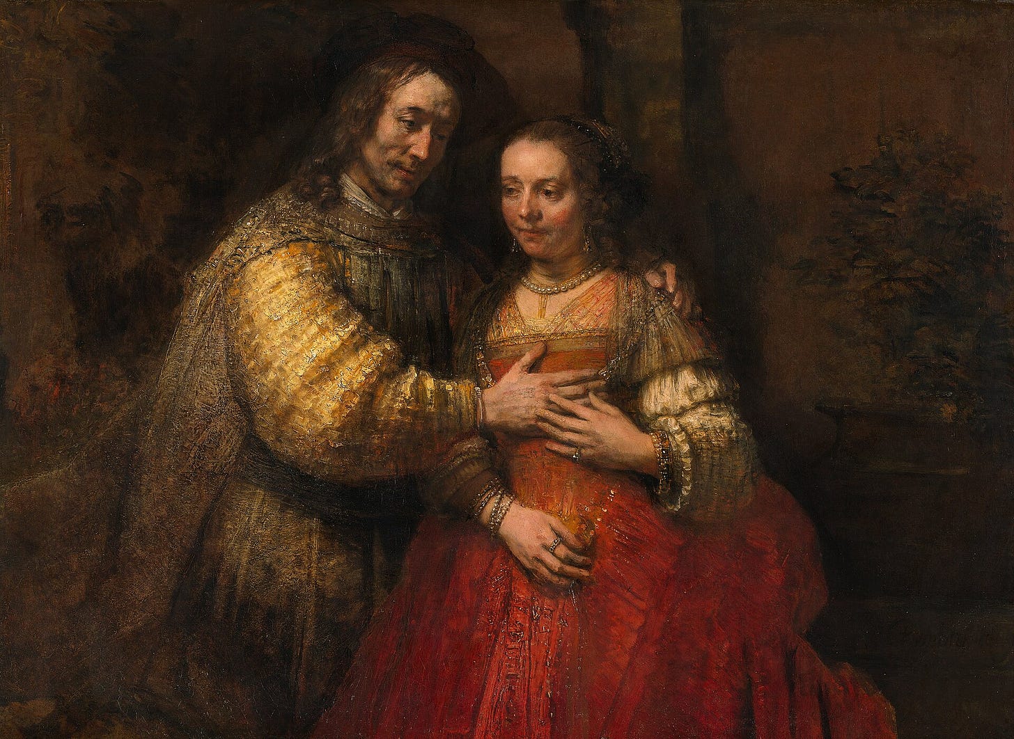The Jewish Bride by Rembrandt: a couple in red and gold, his hand resting on her chest