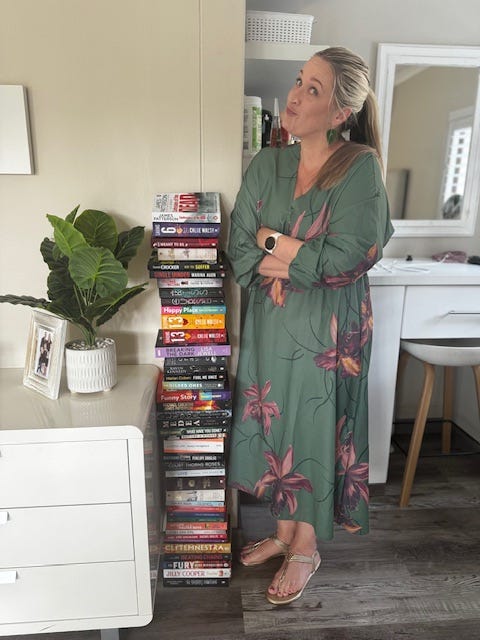 Melissa standing next to a tower of books