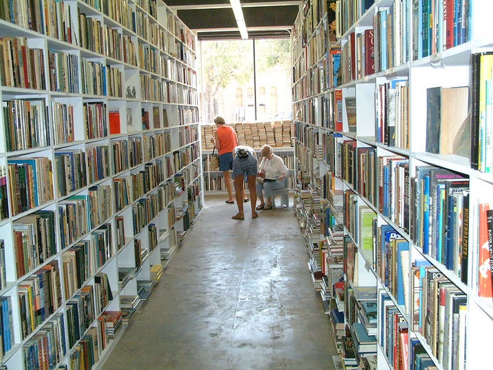 left - a brick building with a sign reading "Booked Up Inc." Right - floor-to-ceiling shelves filled with books