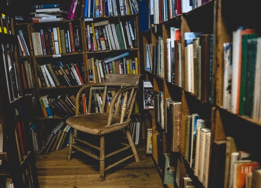 brown wooden chair near brown wooden book shelves