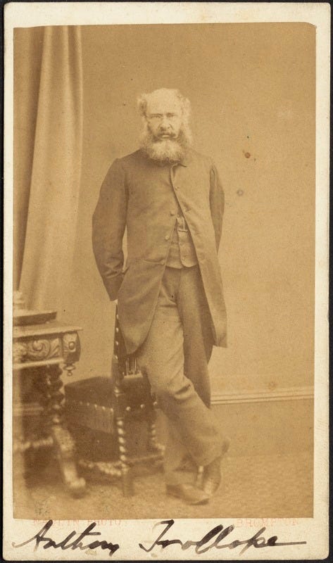 Photograph of Anthony Trollope leaning against a chair, his right leg crossed over the left. His name is written in ink at the base of the image. Photograph of Anthony Trollope leaning against a chair, his right leg crossed over the left. His name is written in ink at the base of the image.