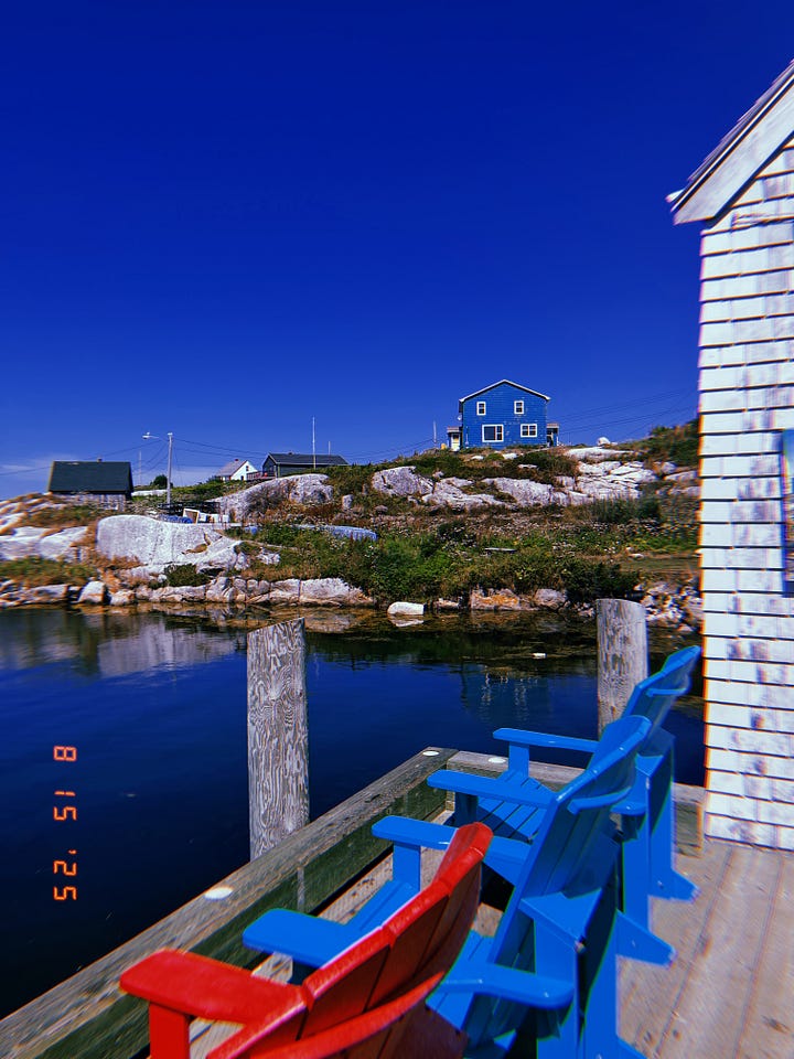 1) From a doc with blue Adirondack chairs, on an ocean inlet, a view of a rocky & grassy cliff where a blue house perches. 2) A large bush of golden yellow flowers on LM Montgomery’s childhood property. 3) A view of the pond, surrounded by greenery, at the Public Gardens in Halifax. 4) A view of the docks at Lunenburg, featuring many boats (including the Bluenose II).