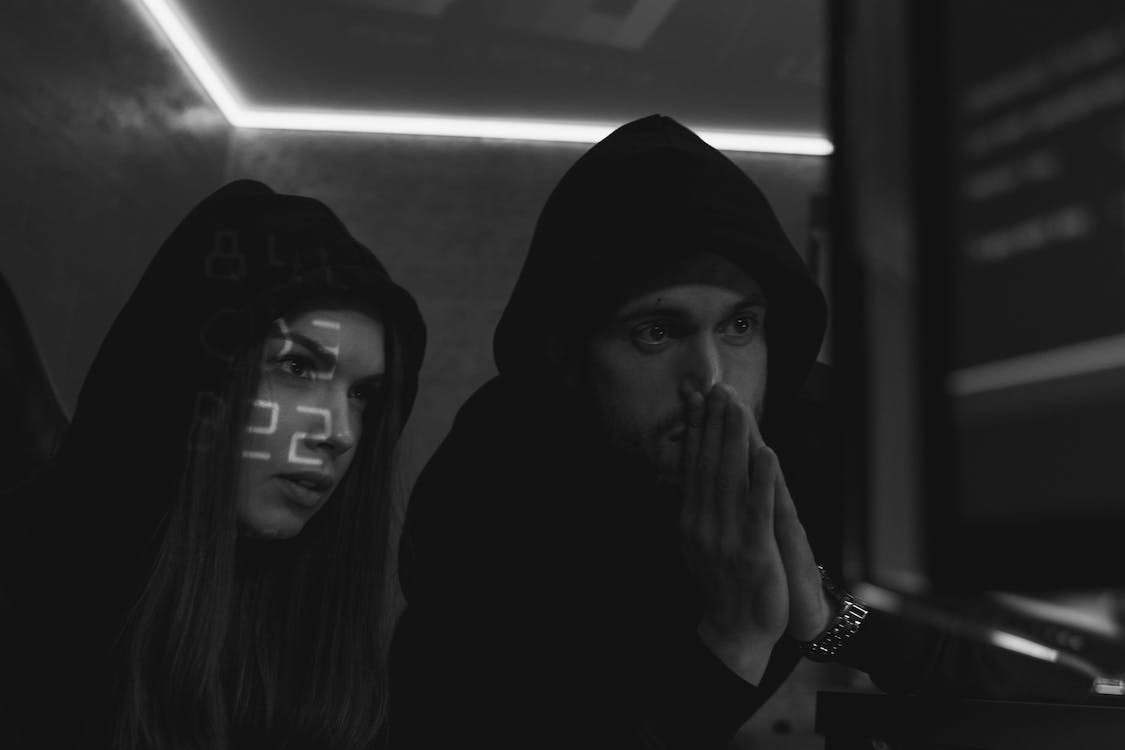 "Grayscale Photo of Man and Woman Hacking a Computer System"