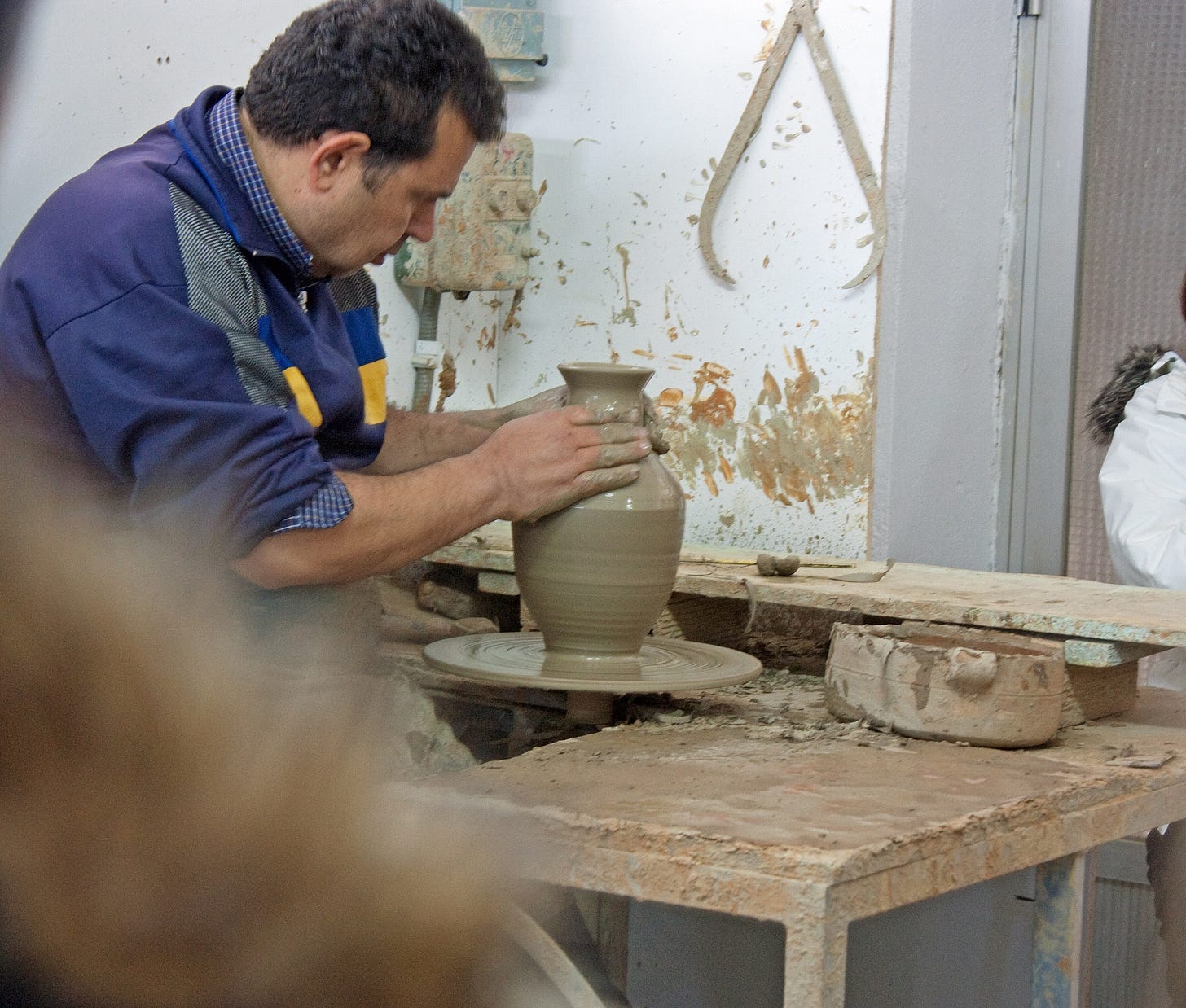 a man making a vase on a pottery wheel. a man making a vase on a pottery wheel.