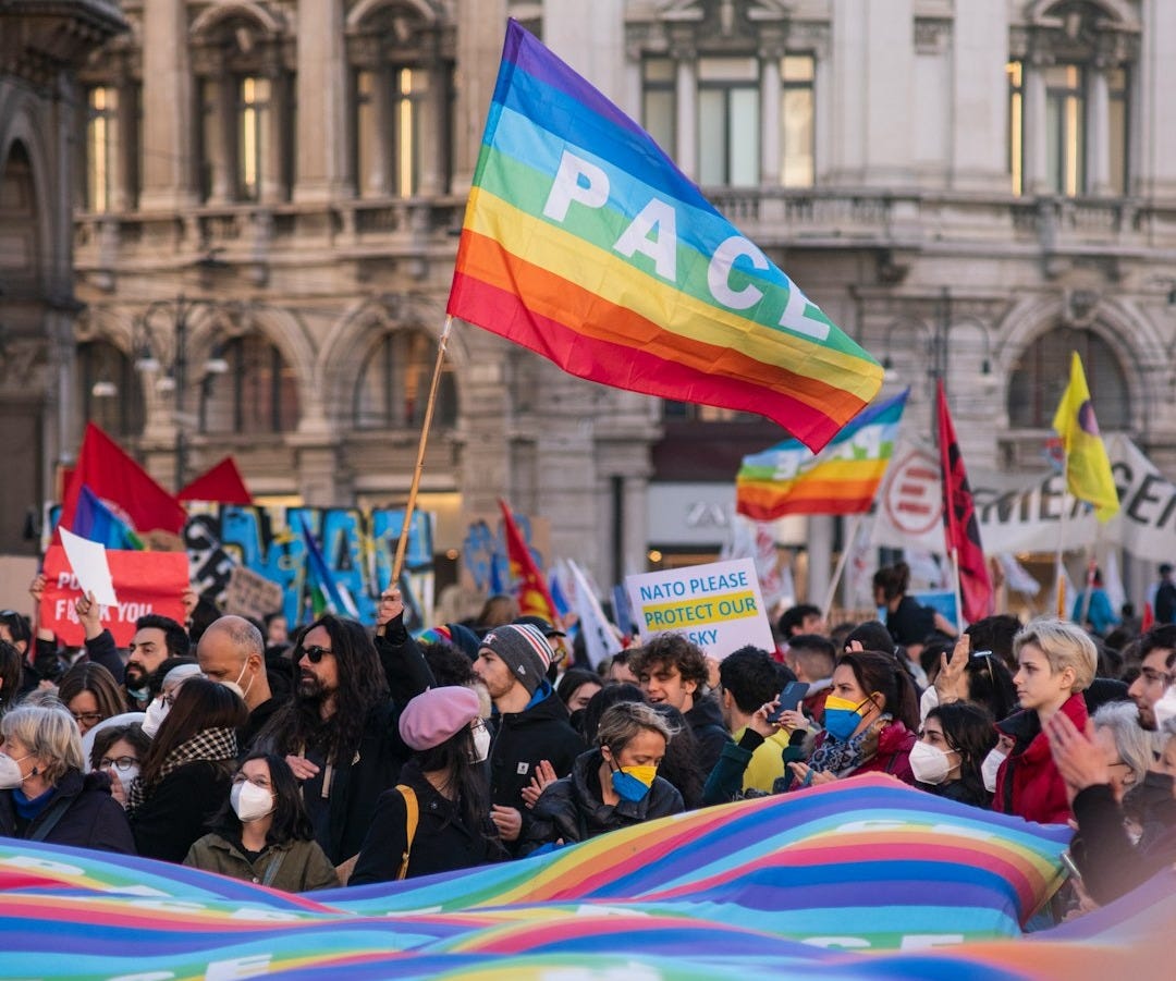 a large group of people holding rainbow flags