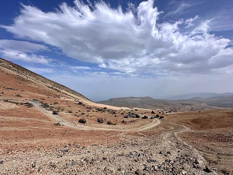 The vast orange desert-like landscape of Montana Blanca in Tenerife, raw and untouched volcanic terrain under bright sunlight.