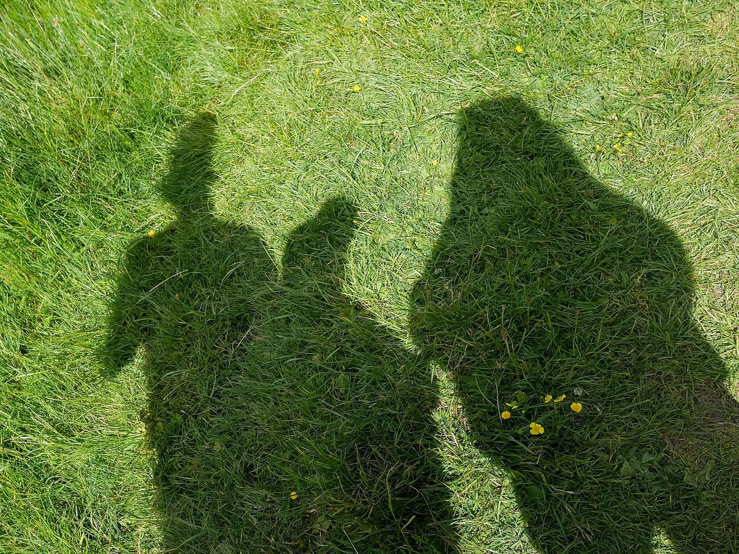 Shadow of a family of three. A man, a women and a child in baseball caps