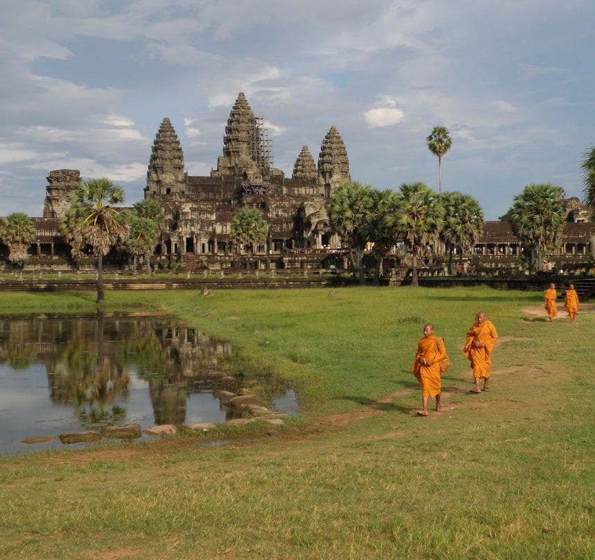 a group of people walking across a lush green field a group of people walking across a lush green field
