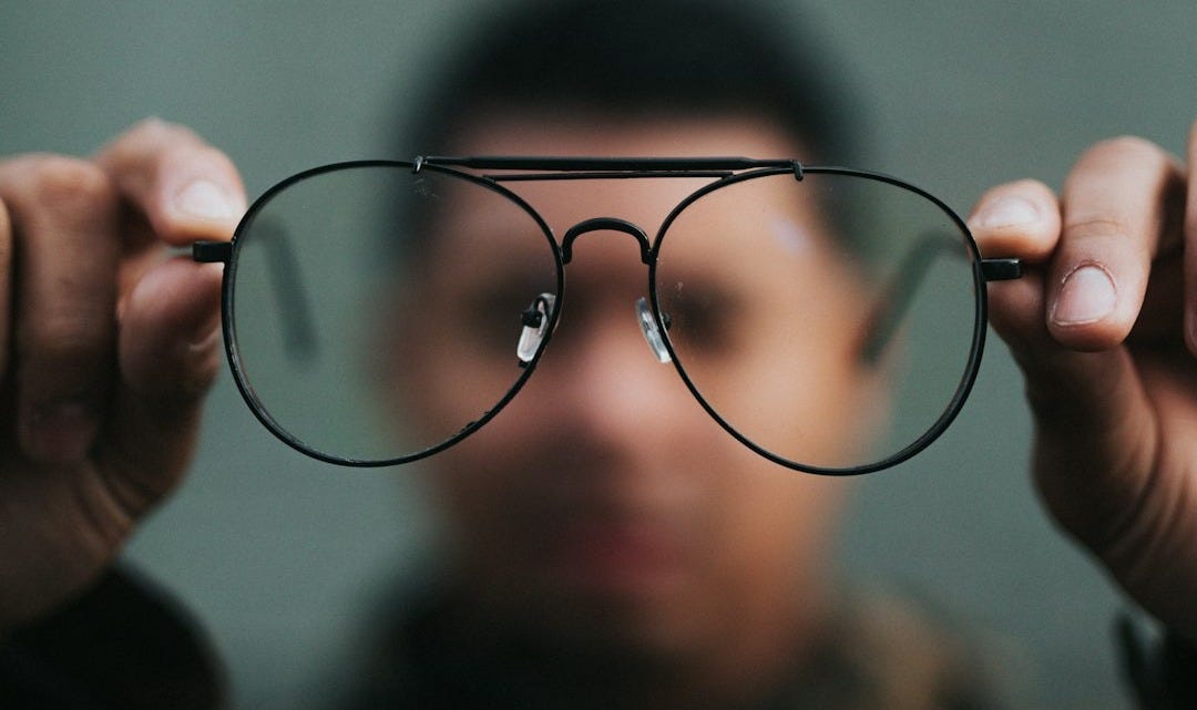 man holding eyeglasses