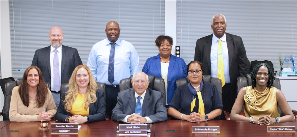 A diverse group of people pose for a group photo at a table. A diverse group of people pose for a group photo at a table.