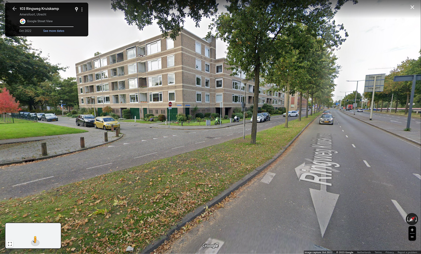 Image shows a four lane arterial road divided from a Service Street by a tree lined boulevard. The Service Street has intersecting roads which do not access the Ring Road.