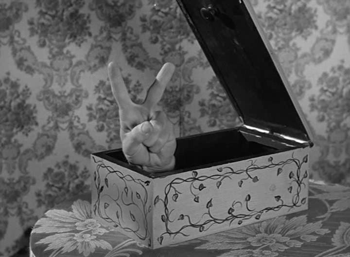 'Thing' from The Addams Family - a disembodied hand appearing from a box to give the V for victory sign with two fingers. 'Thing' from The Addams Family - a disembodied hand appearing from a box to give the V for victory sign with two fingers.