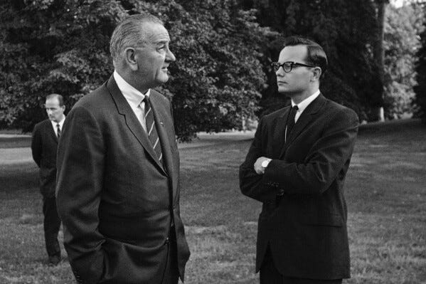 President Lyndon B. Johnson, left, talks with press secretary Bill Moyers on the South Lawn of the White House in Washington on Aug. 30, 1965. (AP Photo/William J. Smith, File)
