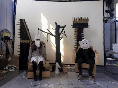 Nine photos of film production crew collecting, painting, building sets with, and filming cardboard.