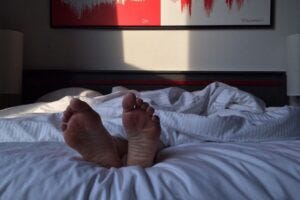 feet sticking out of bed covers