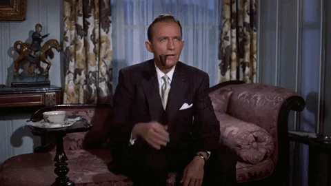 50-year-old Bing Crosby, in a dark suit and silver tie, sits on a brocade sofa, pipe in the corner of his mouth. With a disbelieving look on his face, he takes the pipe from his mouth. (As the gif loops, the pipe reappears in his mouth and Bing gets surprised all over again.)