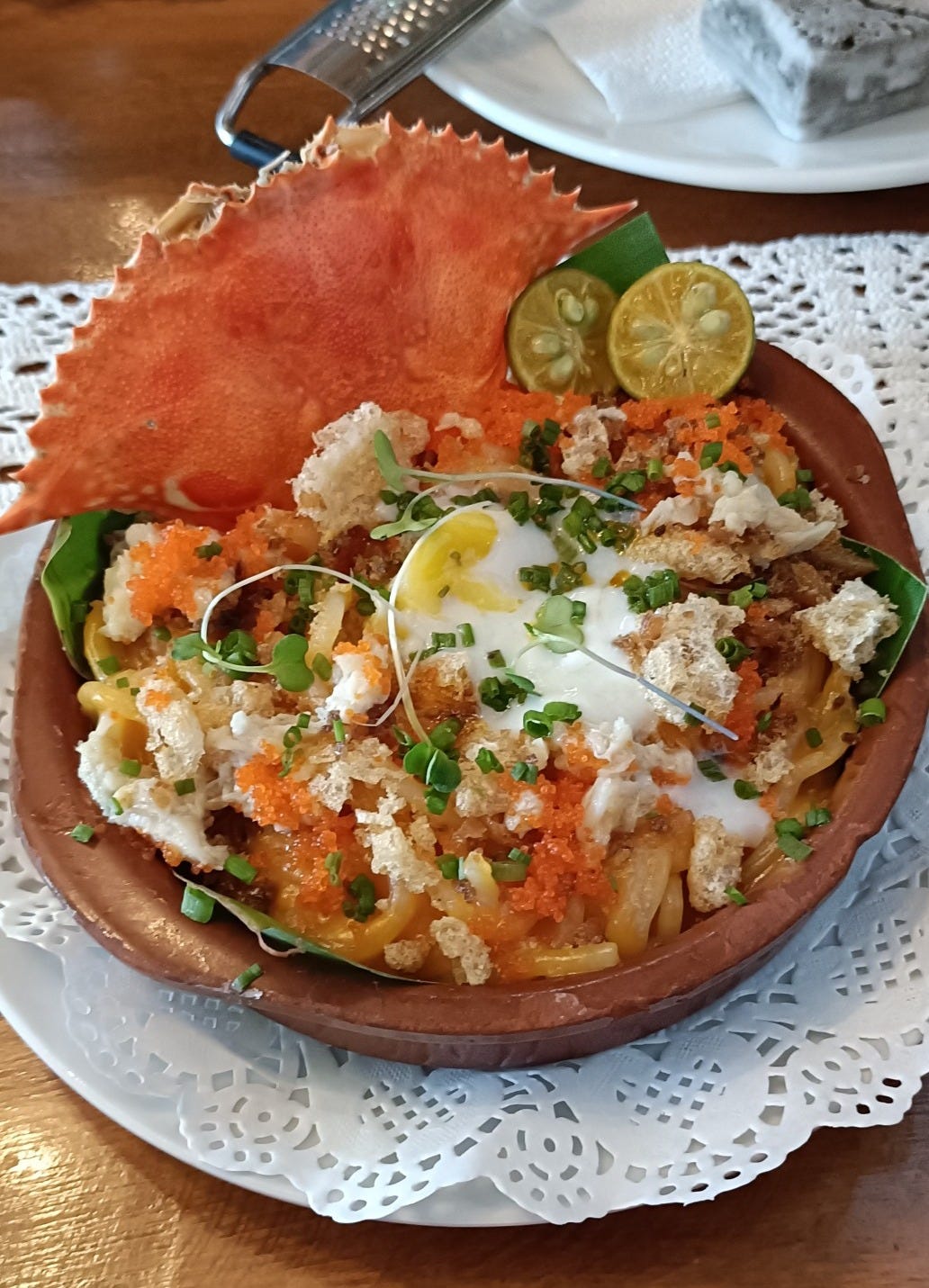 A bowl of palabok with a crab shell as decoration