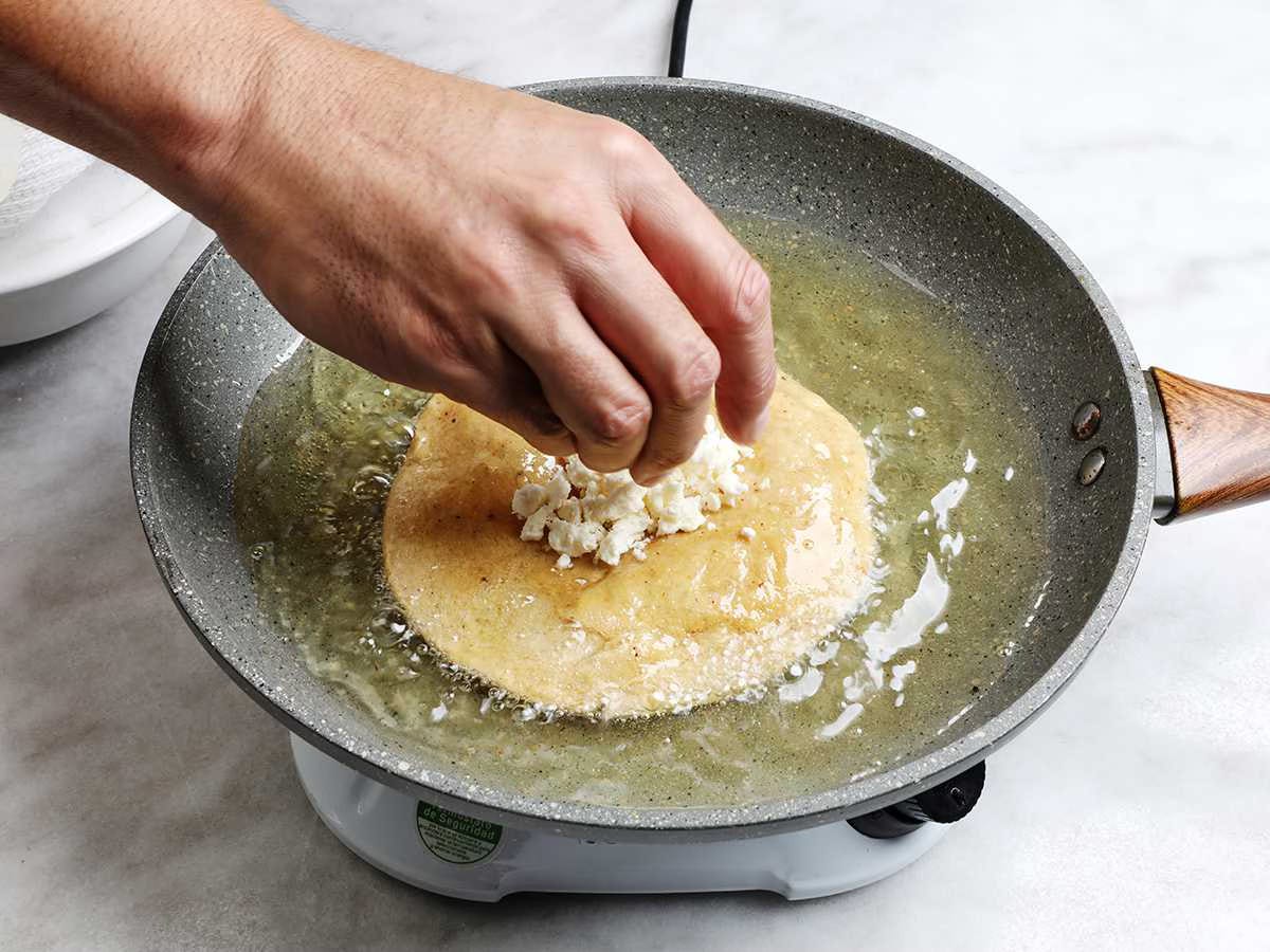 Sprinkling Cheese on Fried Tortilla