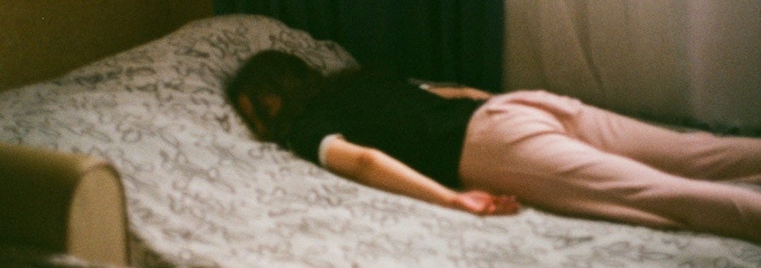 woman in pink shirt lying on bed