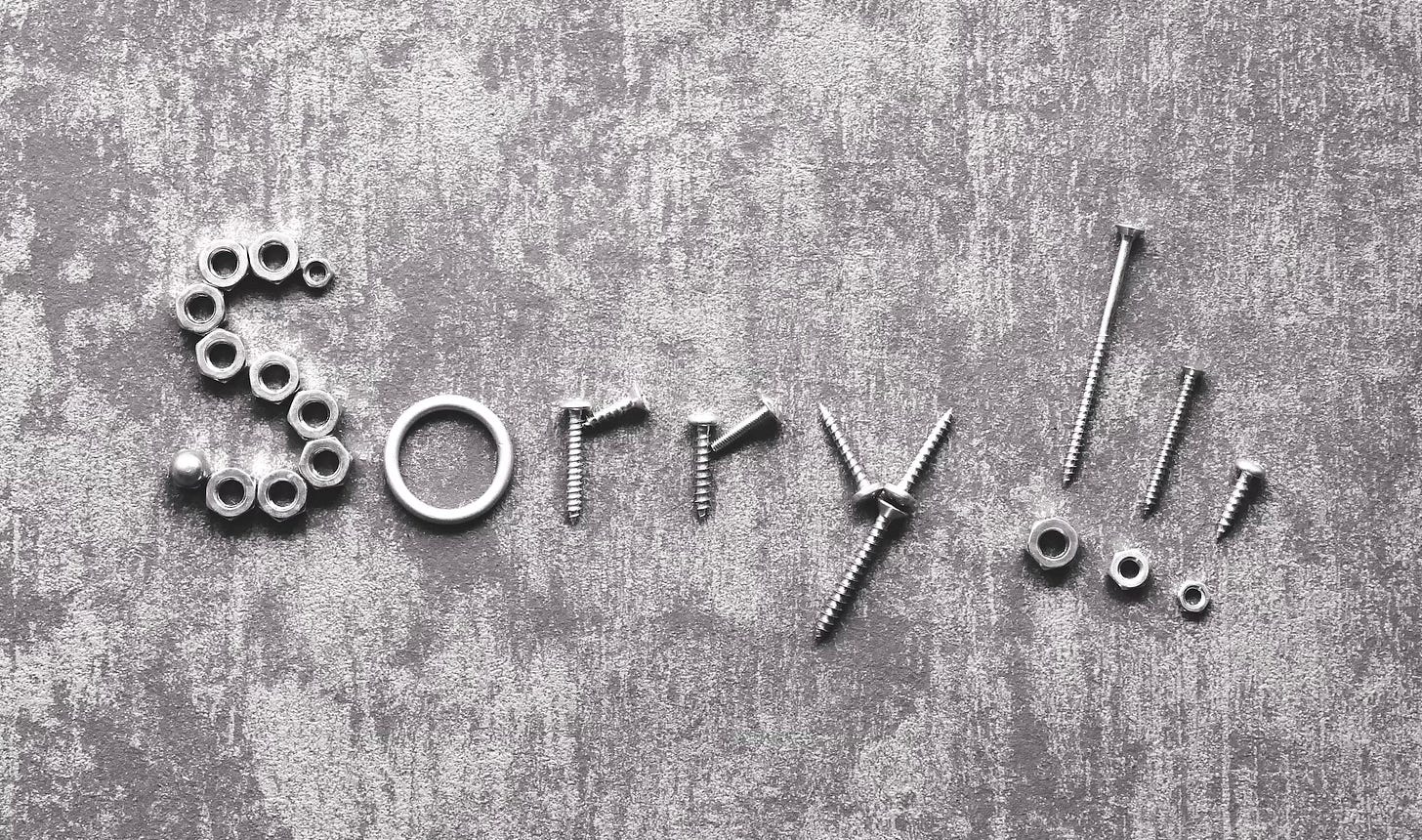 The word "Sorry" punctuated with three exclamation points written with actual nuts and bolts and screws displayed on a grey concrete background. The word "Sorry" punctuated with three exclamation points written with actual nuts and bolts and screws displayed on a grey concrete background.