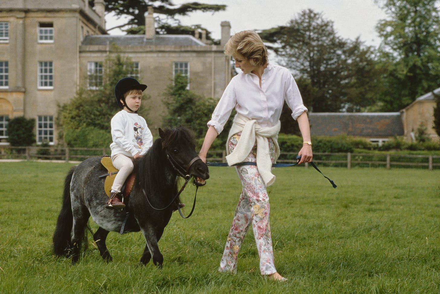 Princess Diana leading Prince William on a Shetland pony