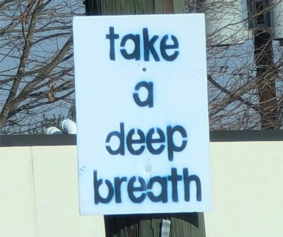 A handmade street sign painted with the words “take a deep breath” reminds us to pause, reset, and find space to restore our creativity.