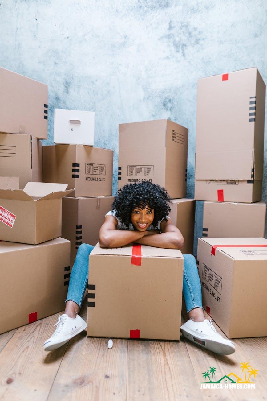 woman in blue denim jeans sitting on brown cardboard boxes