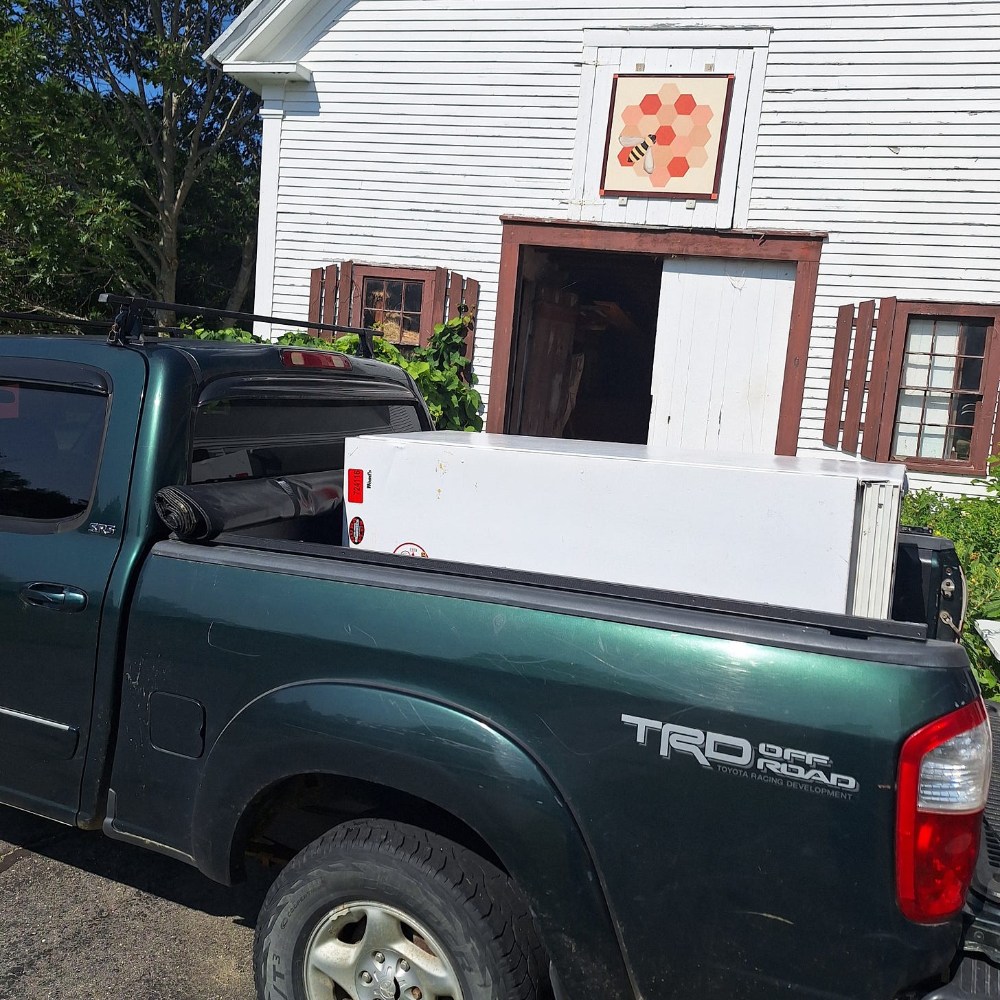 A full-sized refrigerator loaded in the back of a truck, salvaged free from Facebook Marketplace for the Runamuk farmstand.