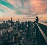 Person sitting on top of the building photo – Free City ...