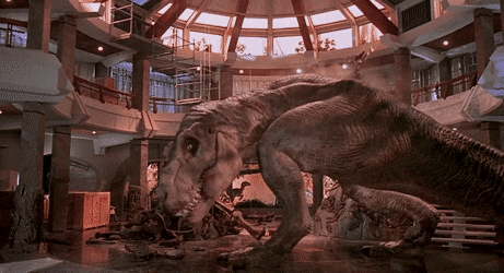 A Tyrannosaurus Rex roaring deeply while a banner reading "when dinosaurs ruled the earth" falls to the ground in front of it