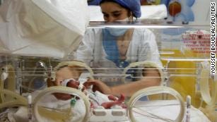 A nurse takes care of one of the newborn nonuplets, lying in an incubator, at the Ain Borja in Casablanca on May 5, 2021.