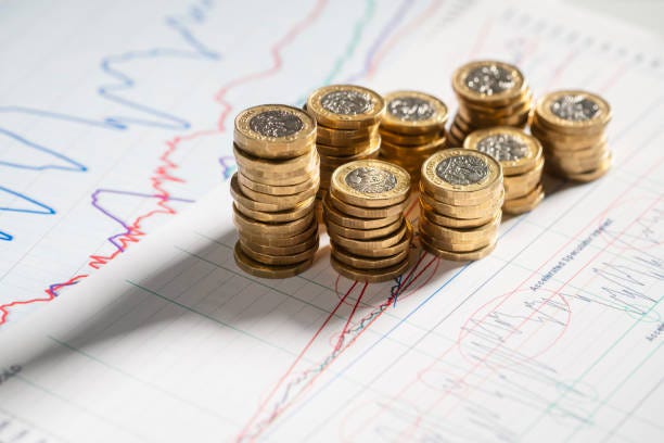 Stack of pound coins on financial graphs and figures Stack of pound coins on financial graphs and figures balance sheet savings stock pictures, royalty-free photos & images