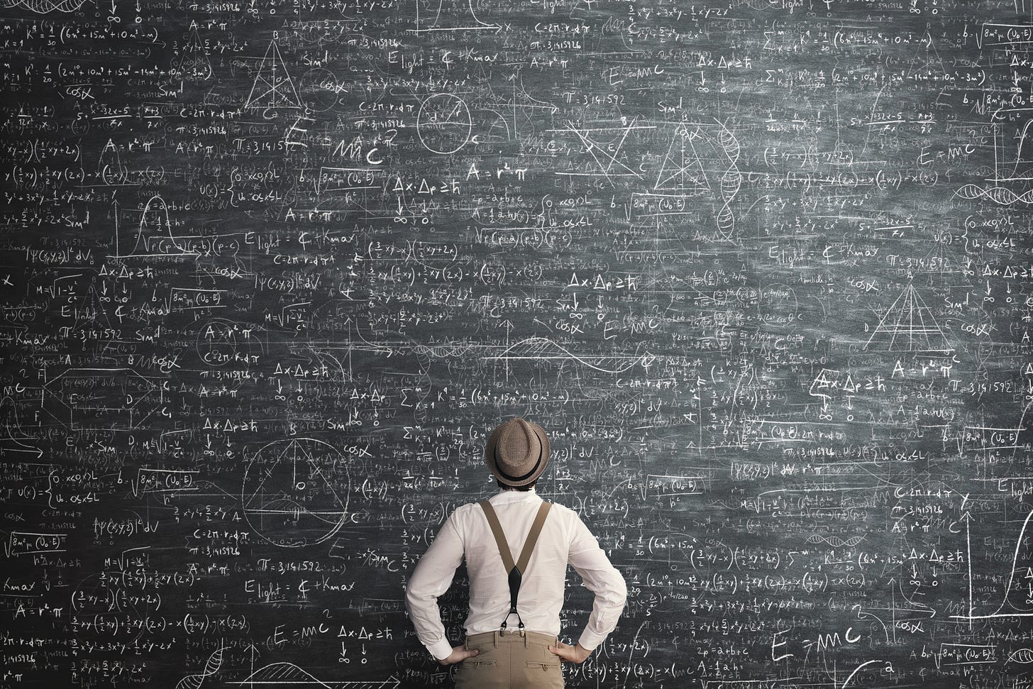 A man looking at a chalkboard covered in math