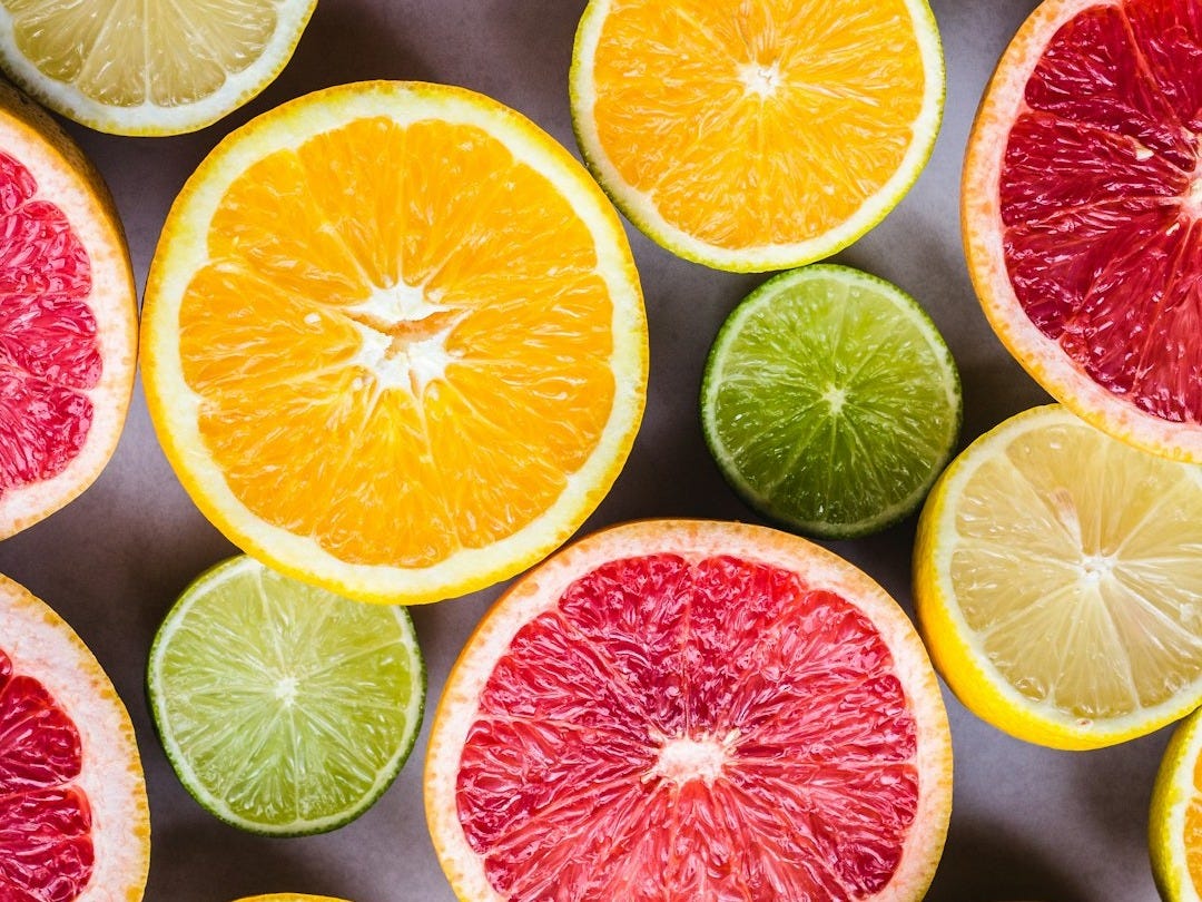 flat lay photography of sliced pomegranate, lime, and lemon
