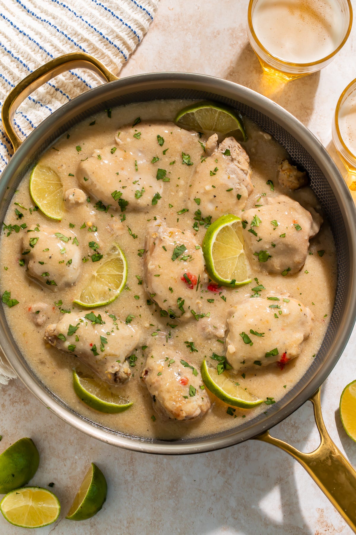 Slow cooker Chicken thighs in a coconut-lime sauce, with slices of lime, in a skillet Slow cooker Chicken thighs in a coconut-lime sauce, with slices of lime, in a skillet