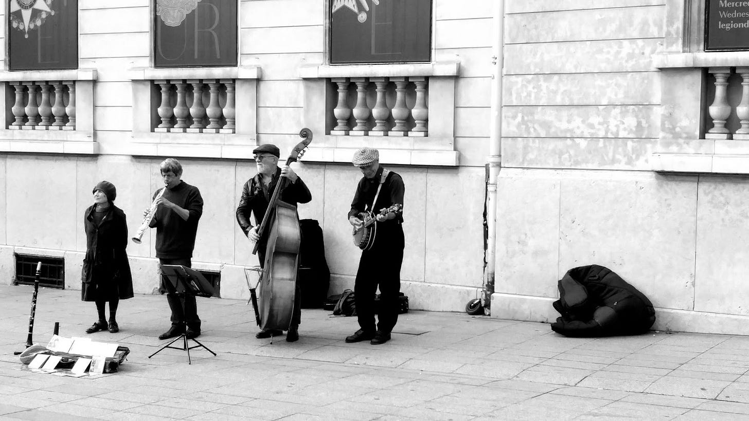 A black-and-whit photo of a musical quartet including a singer, clarinet player, bass player, and banjo player.