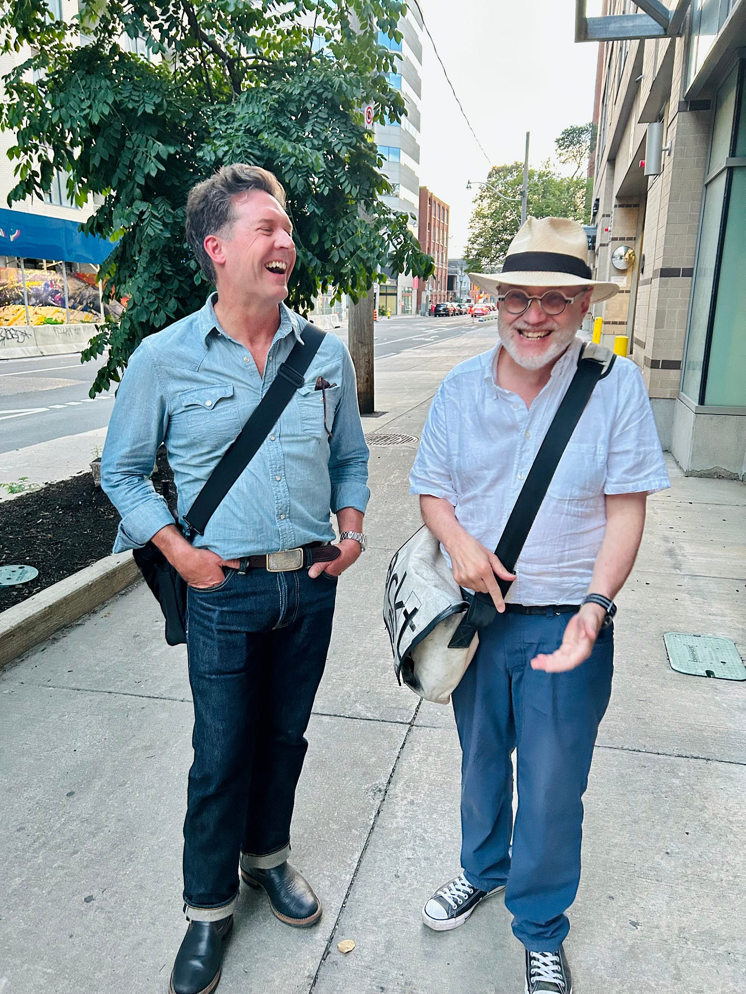 Poets Dale Martin Smith & r. kolewe (KFB designer, laughing along Richmond St. W. Toronto
