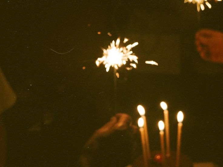 This may contain: someone is lighting candles on a cake with sparklers