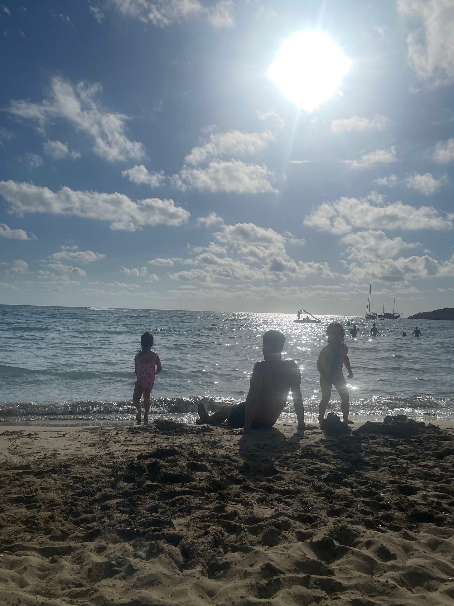 Family on a beach, silhouetted against sun Family on a beach, silhouetted against sun