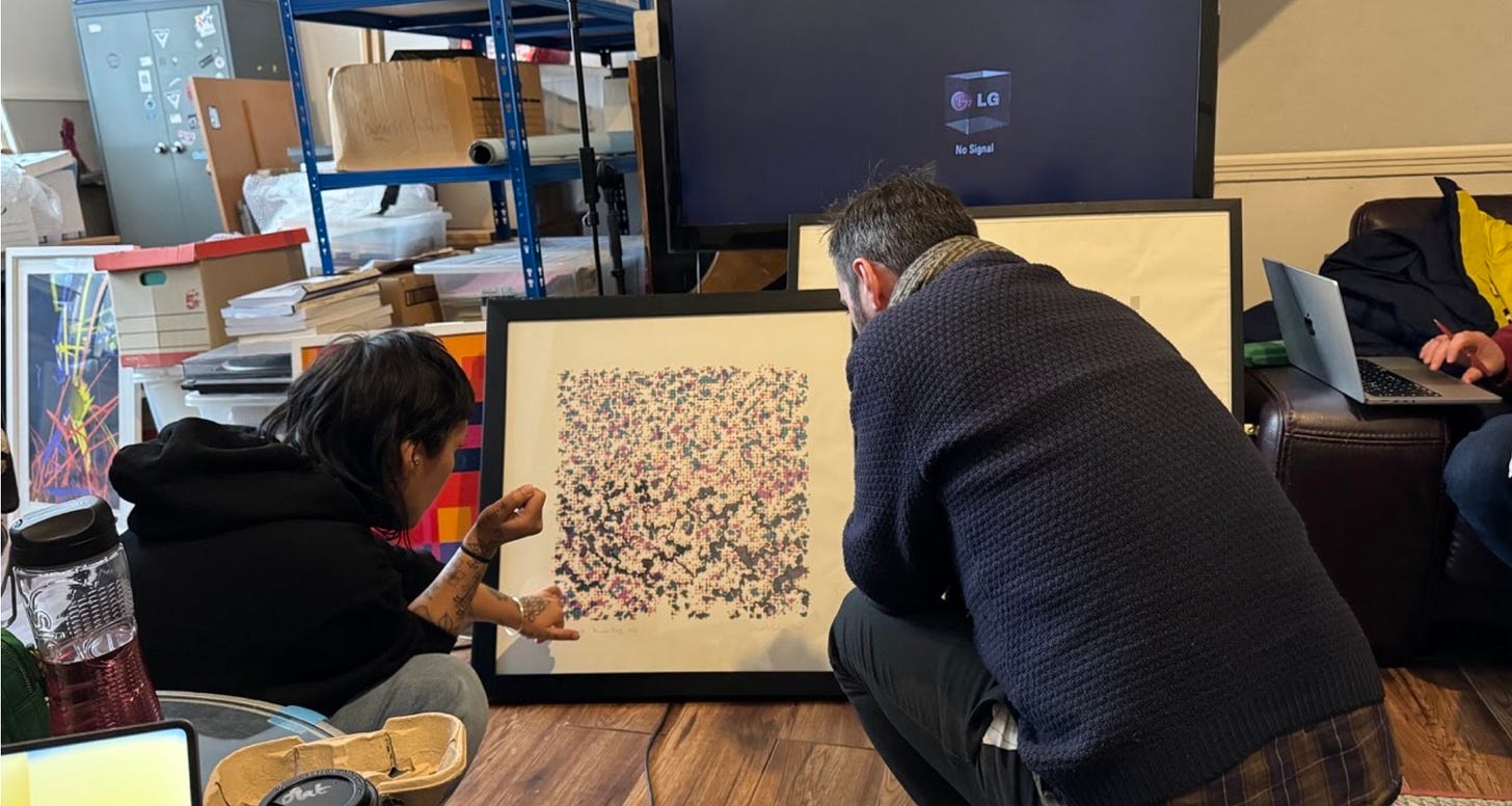 Image of two artists examining a print by Harold Cohen 