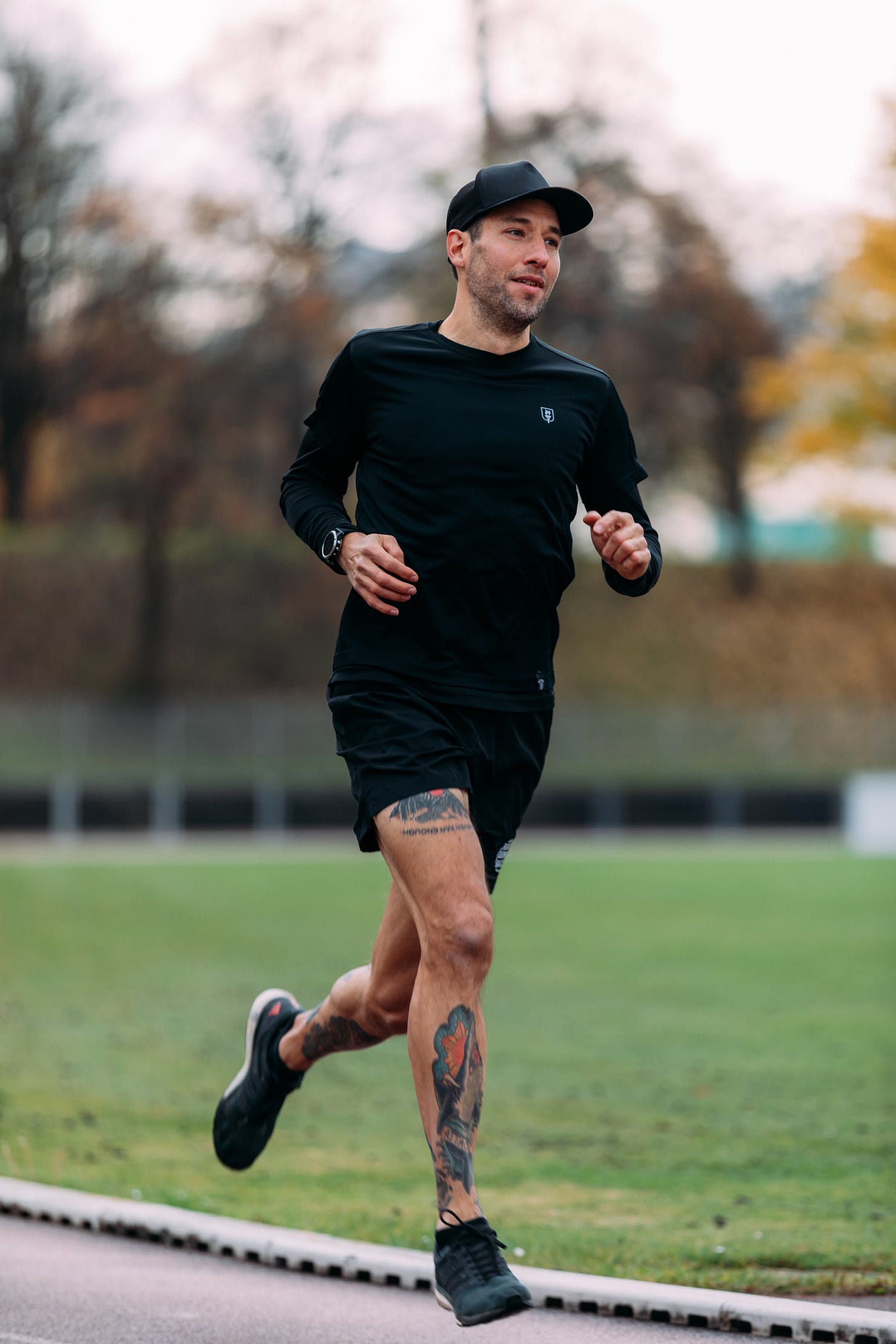The author running on a track with a black hat and a black t-shirt