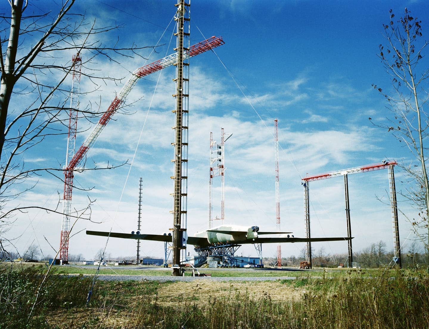 A view of an upside-down B-52 Stratofortness aircraft mounted on a pedestal at the Rome Air Development Center Stockbridge site, September 1979. Antennas around the B-52 are part of a new antenna measurement test facility. The new system allows engineers to determine the effectiveness of aircraft antennas without a test flight. <em>National Archives</em>