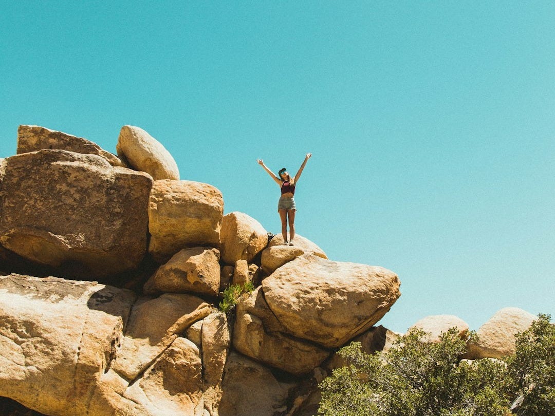 A woman standing on top of a rock formation.