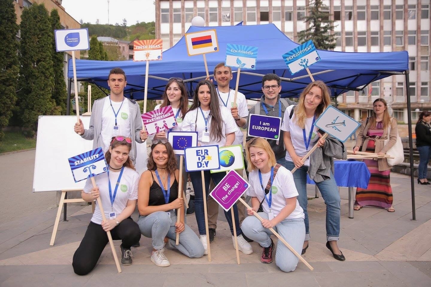 Sophie Vériter, surrounded by volunteers, holding signs at EU Days organised in Gyumri, Armenia in 2017.