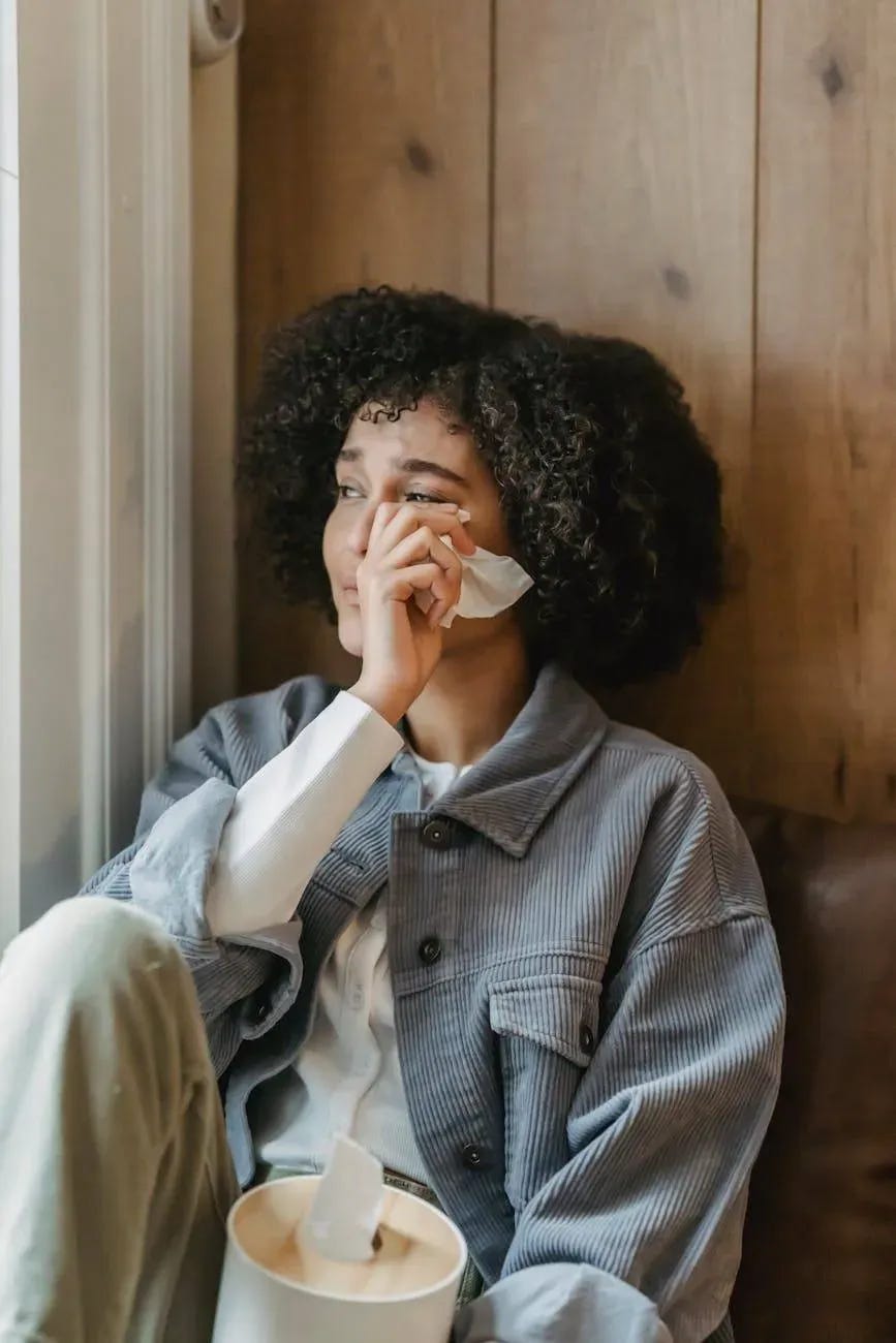 sad young ethnic lady crying near window at home