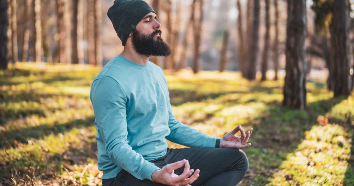 man meditating in the woods