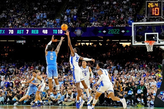 North Carolina guard Caleb Love shoots against Duke center Mark Williams. North Carolina guard Caleb Love shoots against Duke center Mark Williams.