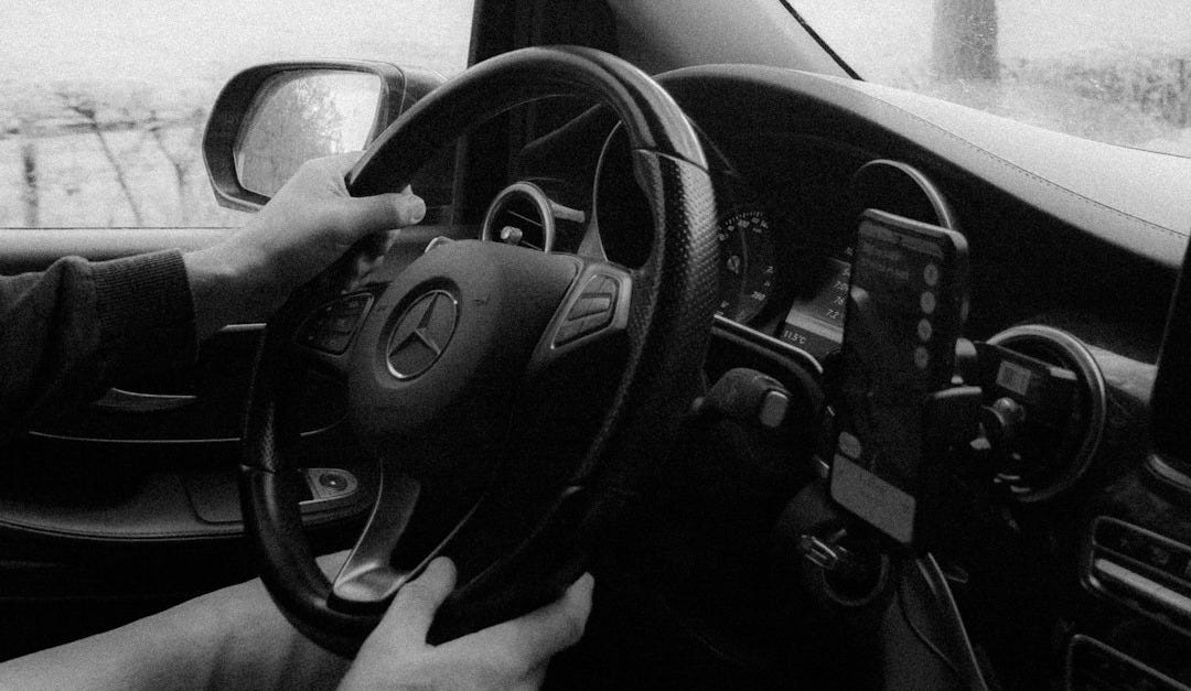 a black and white photo of a man driving a car a black and white photo of a man driving a car