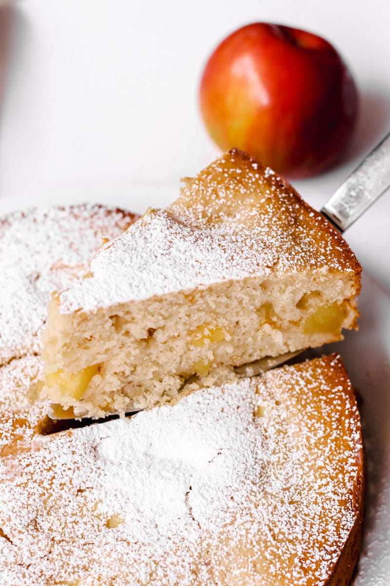 close up of a slice of nonna's Italian apple cake and an apple. 