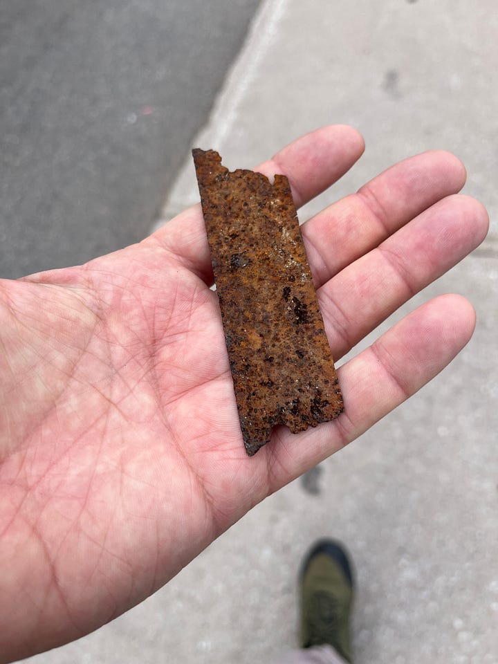 four photos of metal spikes or chunks I've picked up off the ground. The bottom left looks like a very old, hand made nail from the 1800s